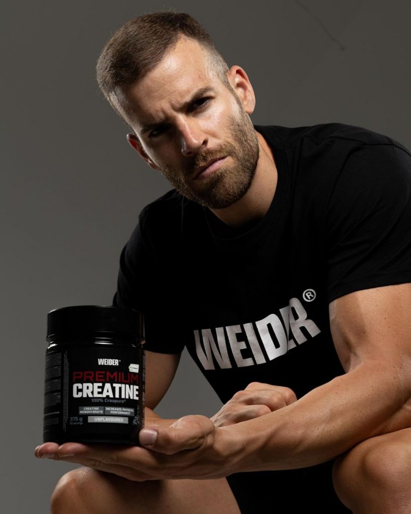 Hombre fuerte con bote de creatina weider